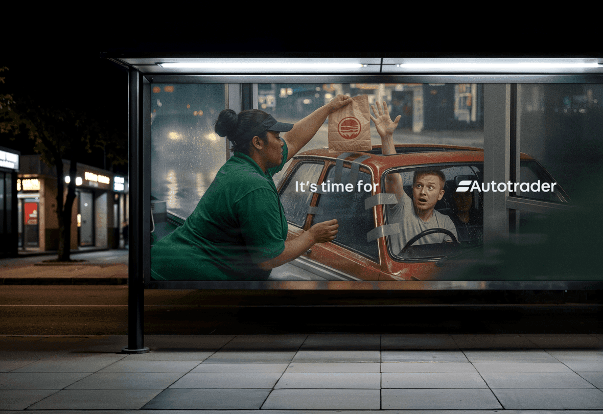 A night-time view of a bus stop advertisement for AutoTrader showing a car-to-window food delivery.