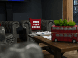 A cozy New York studio space featuring a tufted leather sofa and a London-themed decorative bus.