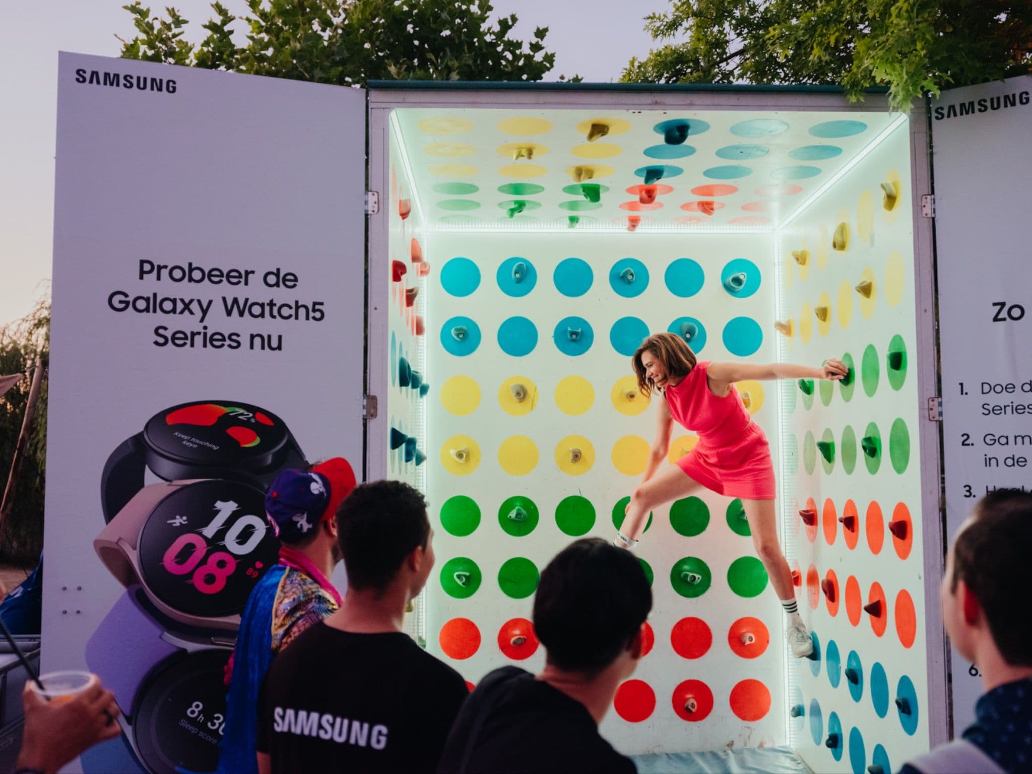 A person jumping inside a colorful interactive Samsung Galaxy Watch promotional display booth.