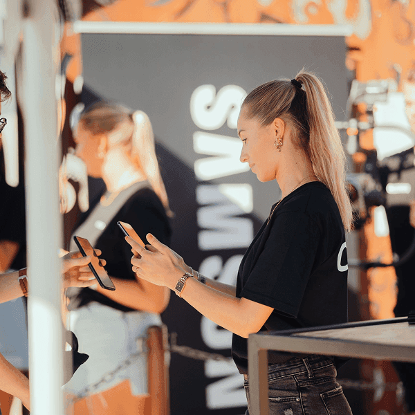 A store associate interacting with a customer holding a smartphone in a retail environment.