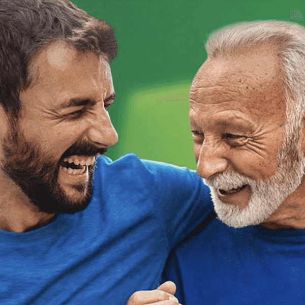 A younger man and an older man with a white beard laughing together in a candid moment.