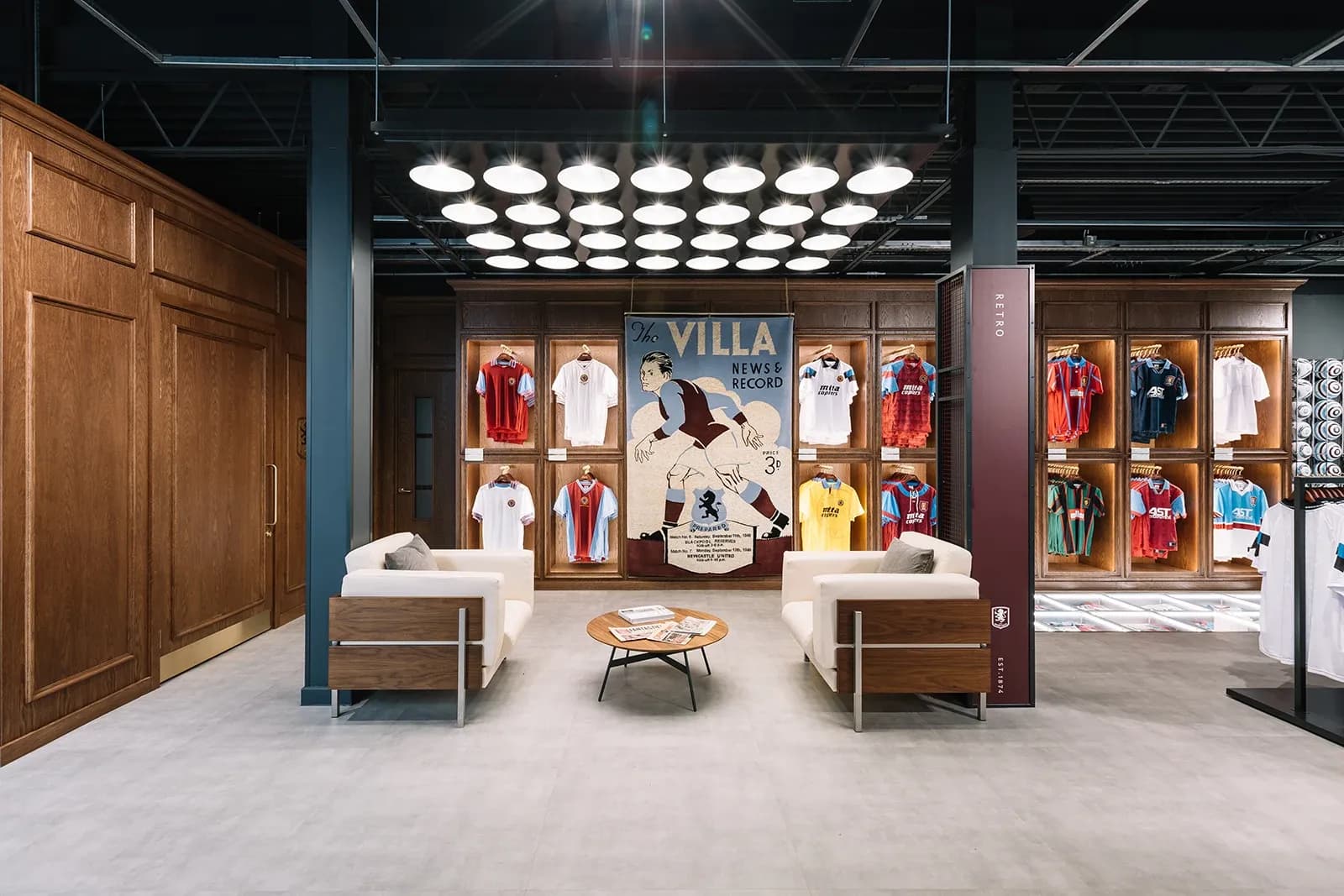"Retro" section of the Aston Villa store with wooden cabinets displaying vintage jerseys and a comfortable seating area.